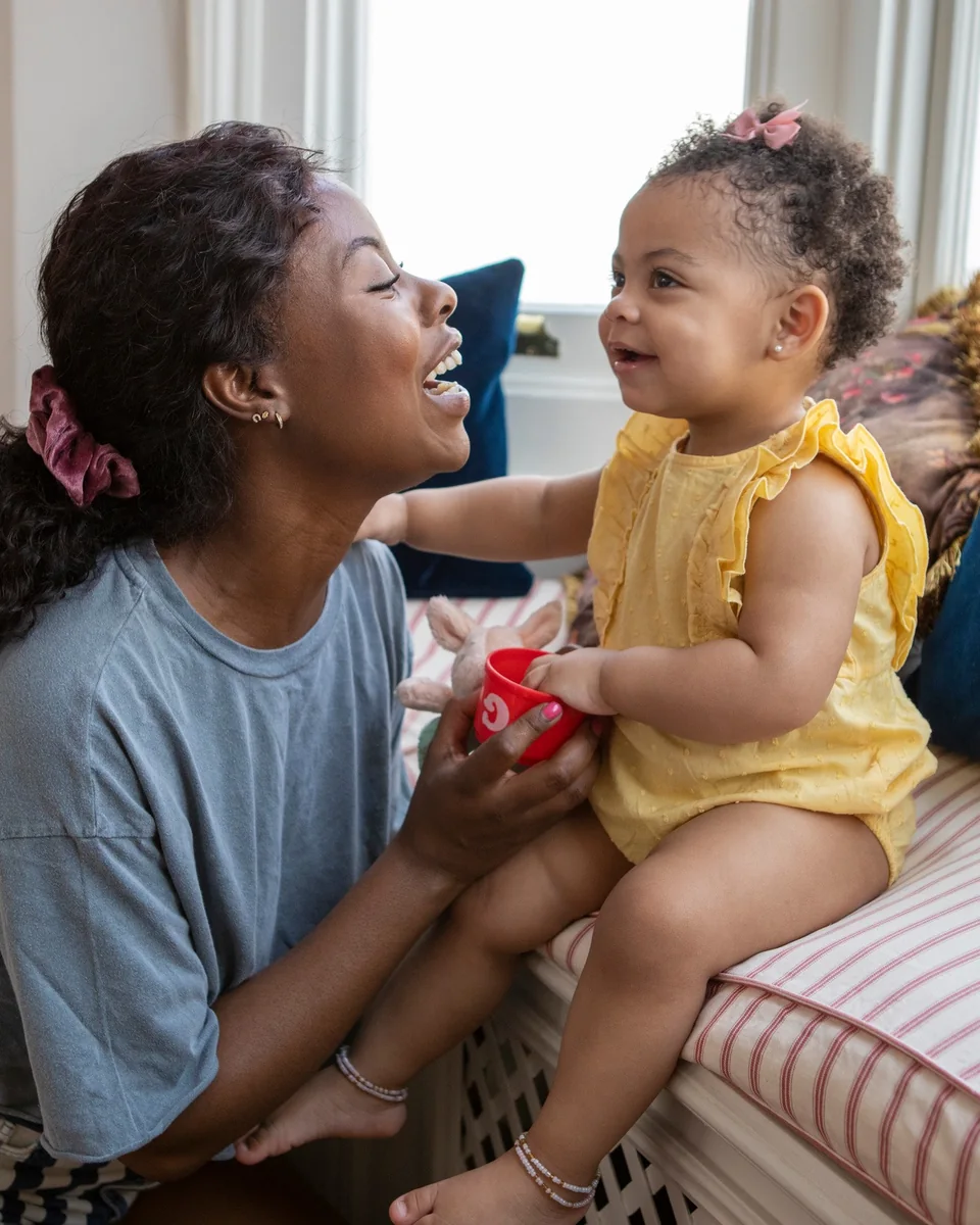 Mãe e filha pequena conversando e sorrindo, olho no olho
